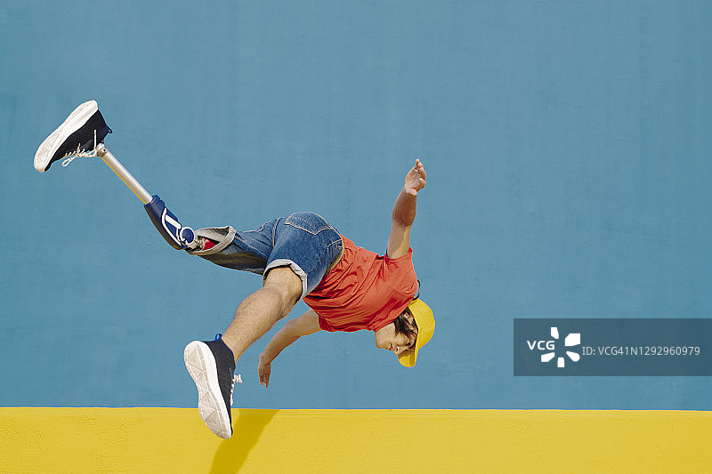 一个装着假肢和假肢的人跳向多色的墙壁图片素材