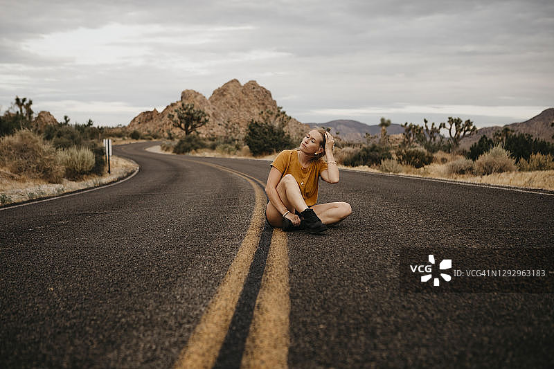 坐在路上的女人，约书亚树国家公园，美国加利福尼亚州图片素材