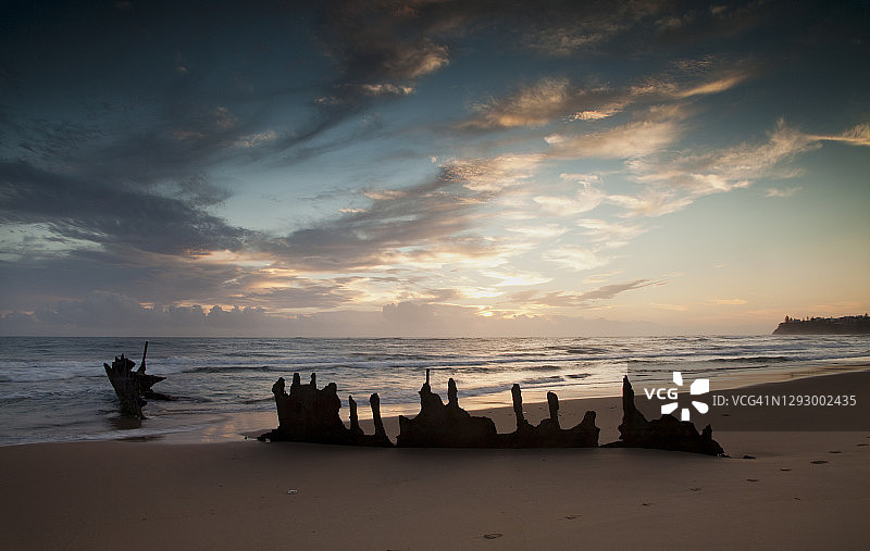 一个戏剧性的日出在迪基海滩与SS迪基的残骸在前景和梦幻般的漩涡海浪，阳光海岸，QLD，澳大利亚。图片素材