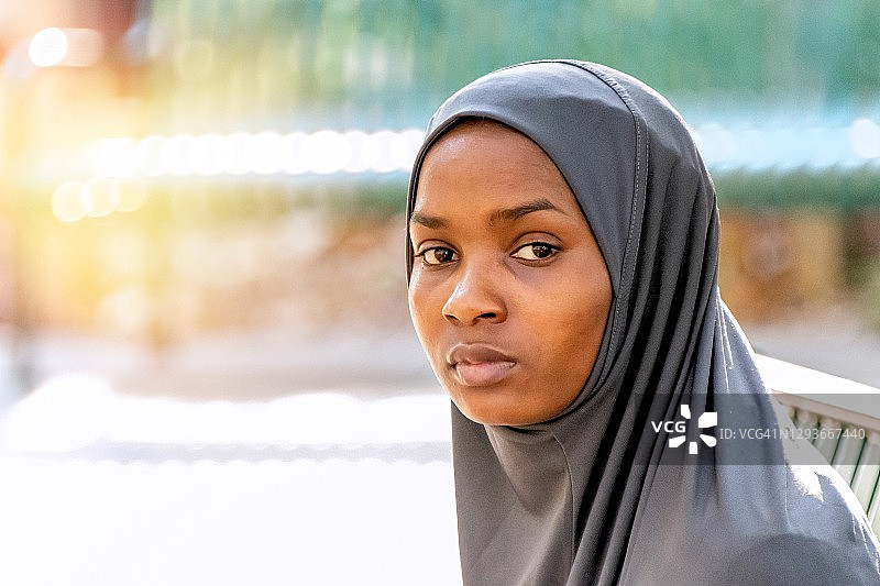沉思严肃的年轻黑人穆斯林妇女戴着头巾看着镜头图片素材