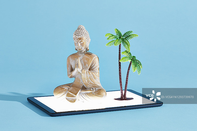 数字平板电脑上的佛像和棕榈树图片素材