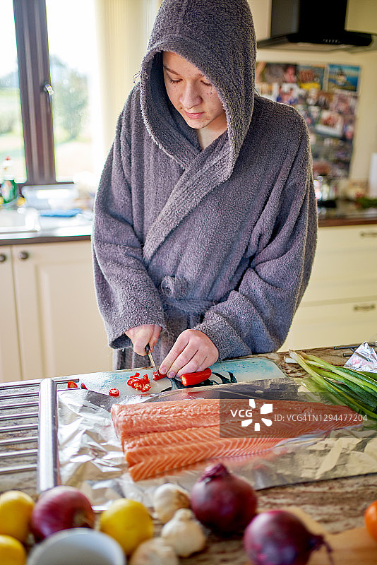 一个十几岁的男孩正在准备鲑鱼片图片素材