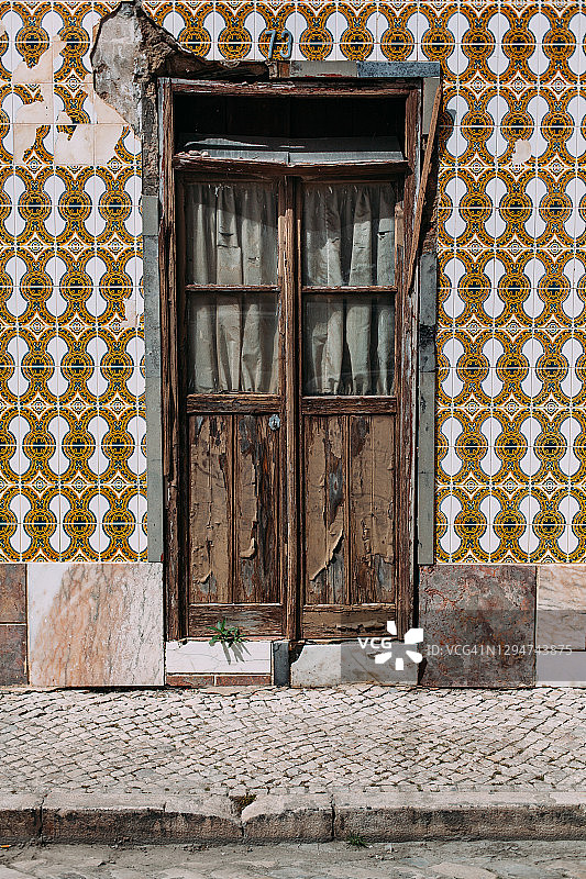 葡萄牙街道上的乡村和风化的木制前门图片素材
