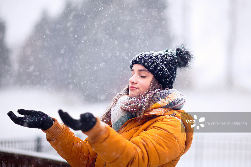少女享受飘落的雪花图片素材