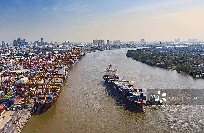 航拍前视图:拖船推集装箱货轮到码头商港进行商业物流、进出口、航运或货运。图片素材