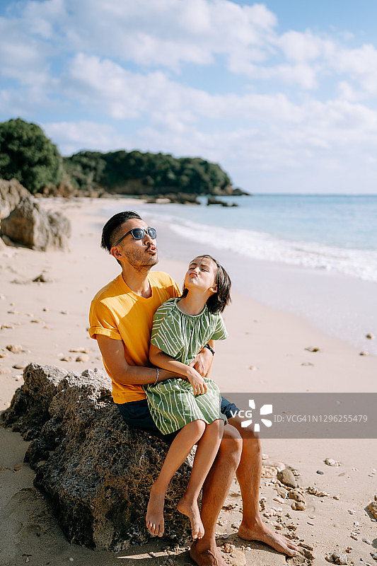 愉快的父亲和年幼的女儿在日本的海滩上图片素材