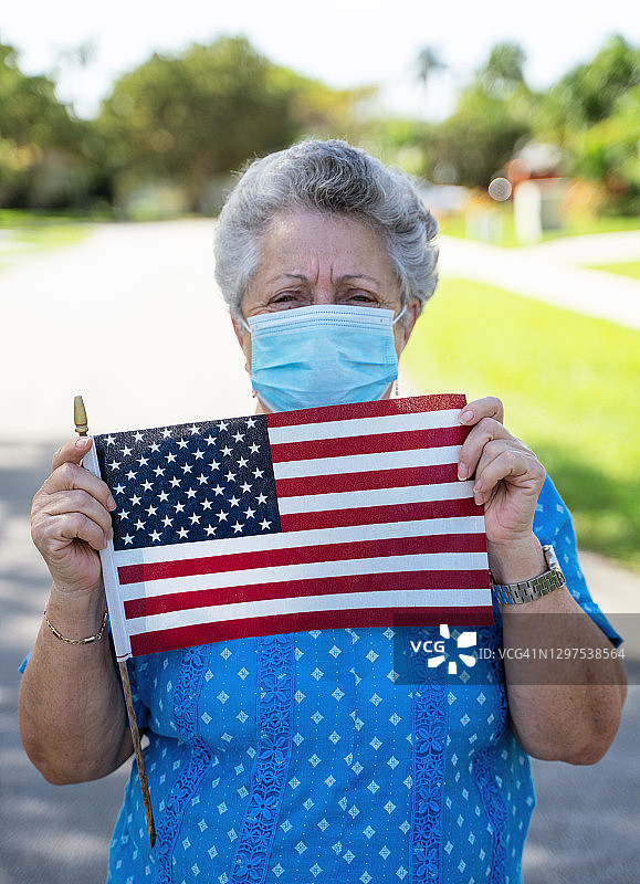 西班牙奶奶戴着面具举着美国国旗图片素材