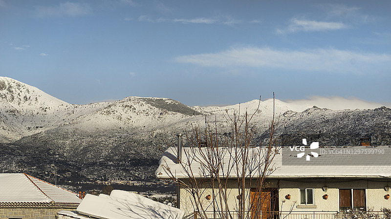 西班牙马德里北部的一个小村庄，屋顶上的降雪。背景是白雪皑皑的蓝天图片素材