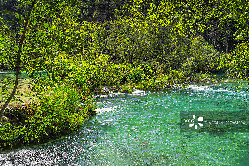 Plitvice湖，梯田湖，水的瀑布环绕着绿色的苔藓岩石图片素材
