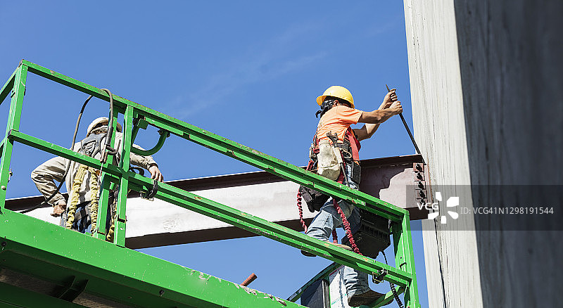 钢铁工人在建筑工地安装大梁图片素材