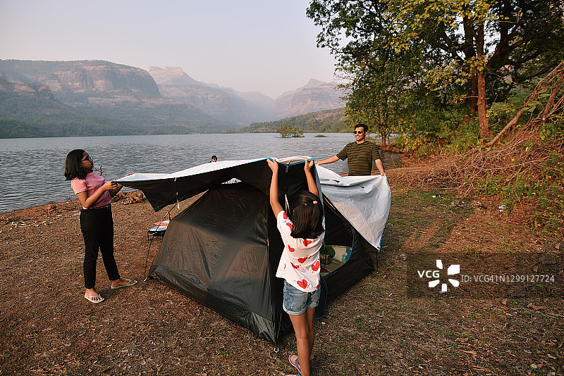 父亲和孩子们在美丽的湖边搭起了露营帐篷图片素材