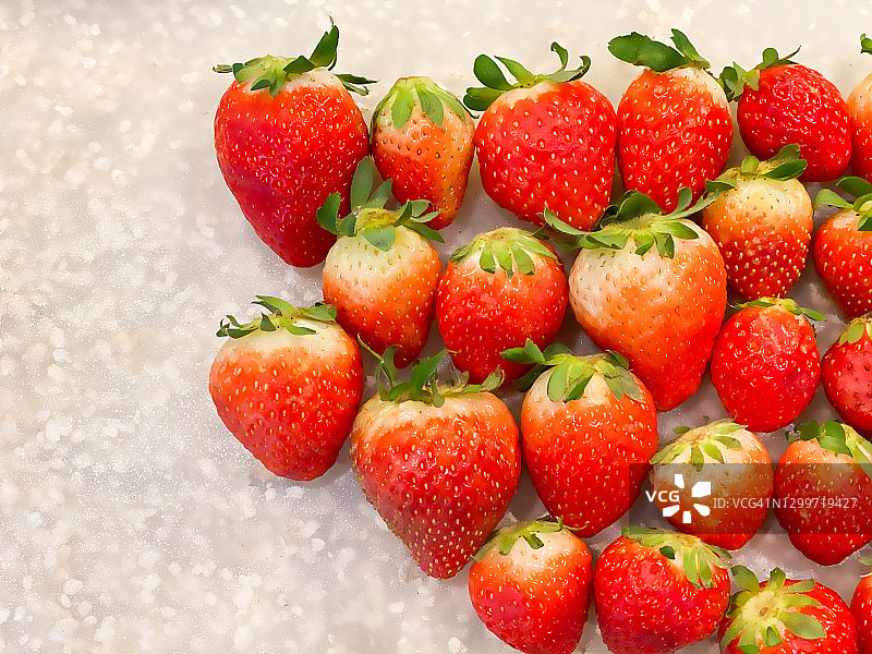 在白色的背景上放置新鲜的有机红草莓图片素材