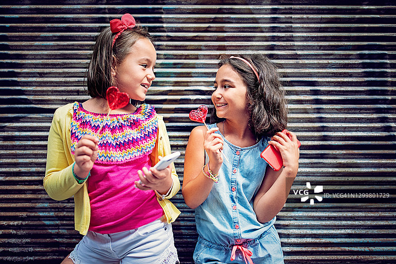 女朋友们吃着心形棒棒糖玩得很开心图片素材