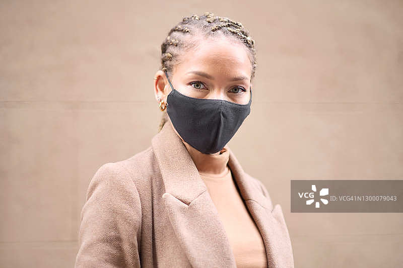 一名年轻女子戴着黑色防护面罩的大头照。图片素材