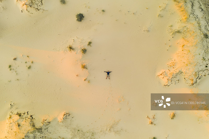人躺在沙漠的沙上，鸟瞰图片素材