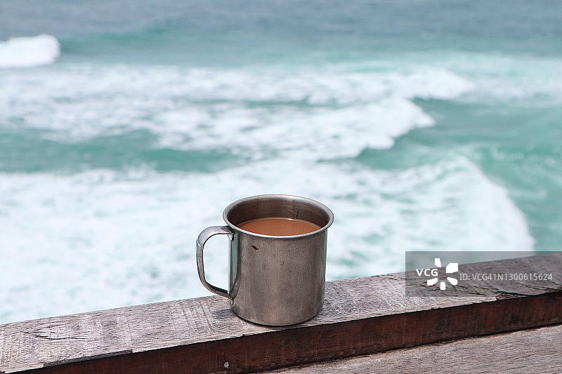 对着海洋的一杯咖啡的特写图片素材