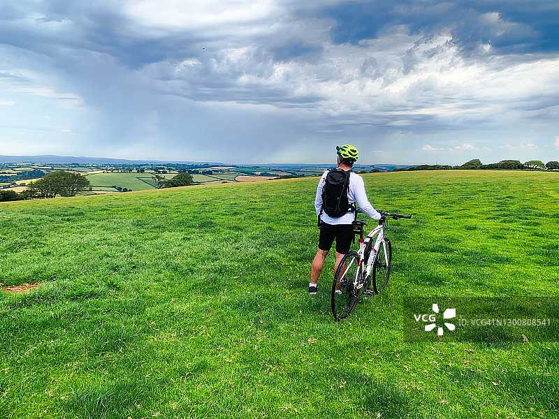 在英国德文郡，骑自行车的人欣赏山顶的景色图片素材