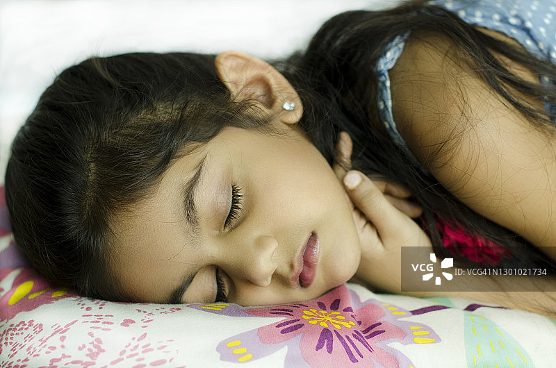 美丽的肖像一个可爱的印度儿童模型在睡觉的姿势图片素材