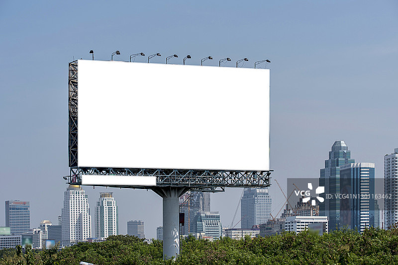 在城市的晚上，有灯笼和大的空白广告牌的道路图片素材