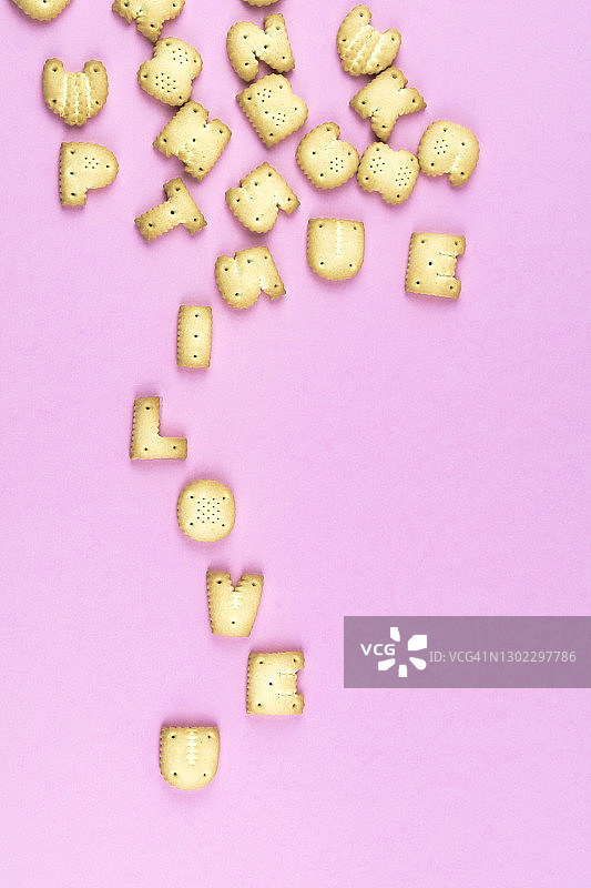 粉红色背景上用饼干写的“我爱你”图片素材