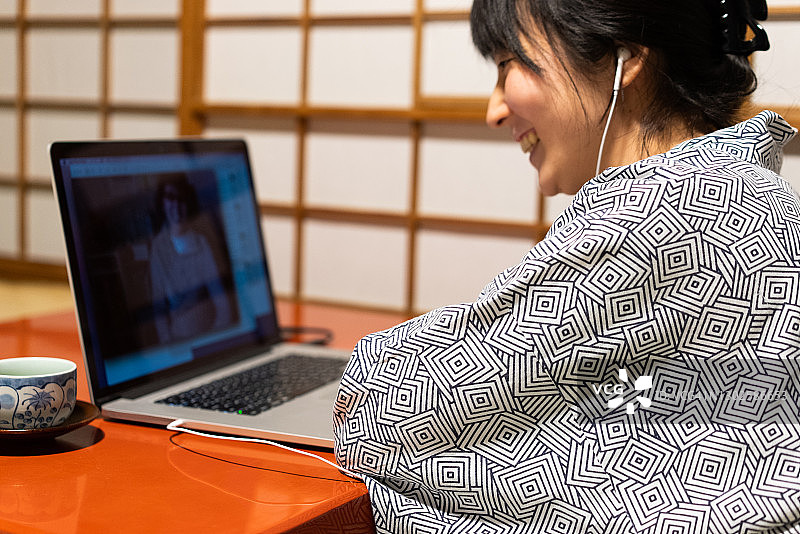 一个正在日本风格的旅馆里使用电脑的女人。图片素材