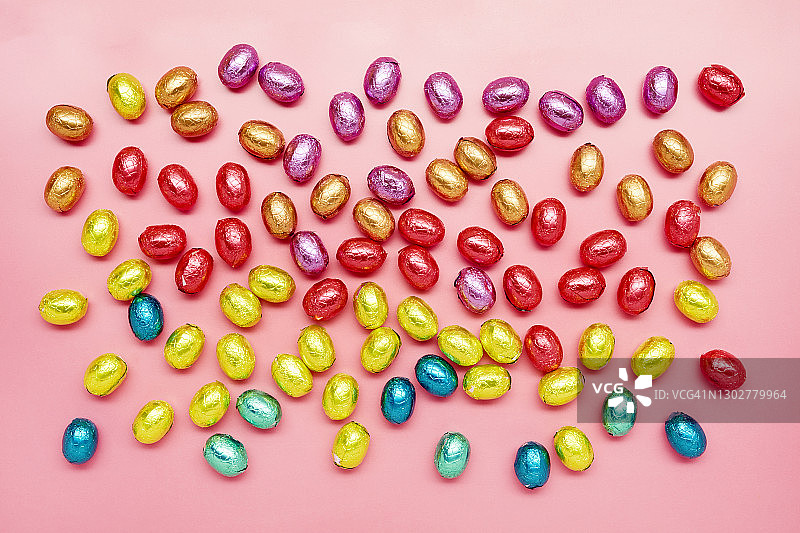 正上方的彩色巧克力复活节彩蛋在粉红色的背景图片素材