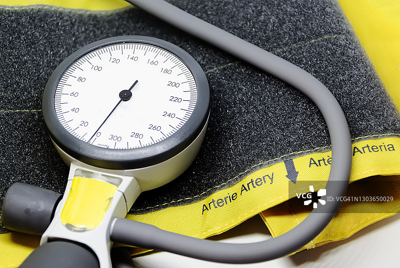 成人用的黄色袖口上的便携式血压计。图片素材