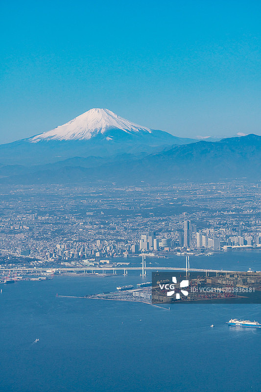 白雪皑皑的富士山和日本横滨市的飞机鸟瞰图图片素材