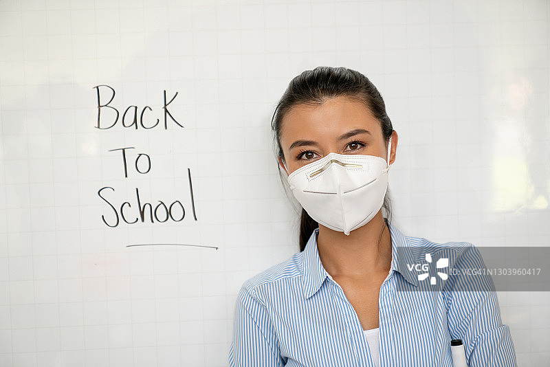 2019冠状病毒病大流行期间，教师返回学校时戴口罩图片素材