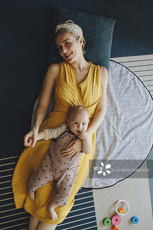 一个可爱的肖像:一个微笑的年轻母亲在家里与她可爱的宝贝女儿度过宝贵的时间图片素材