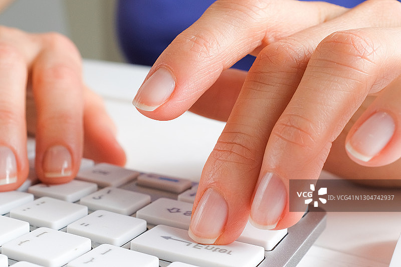 女人的手在电脑或笔记本电脑的键盘上打字。一个办公室职员坐在他的办公桌前。商业、自由职业、在家工作的概念。图片素材