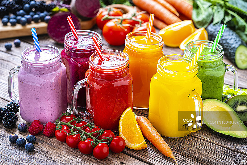 健康的彩虹色水果和蔬菜冰沙放在质朴的木桌上图片素材