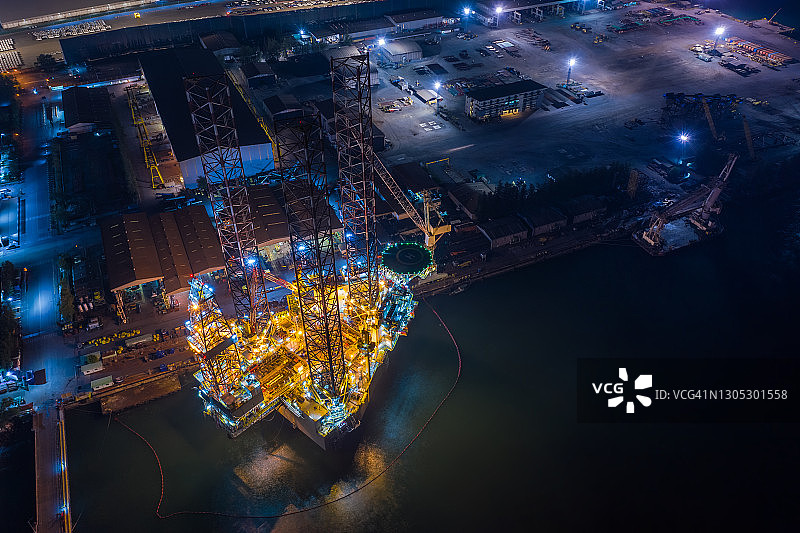 World at work drone view of Oil and gas自升式钻井平台在船厂进行维护与许多船只，石油钻机是应用于生产石油和天然气在海上在石油工业。图片素材