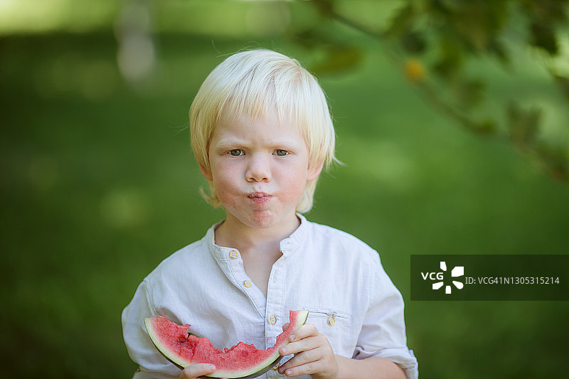 小男孩吃西瓜片的肖像-库存照片图片素材