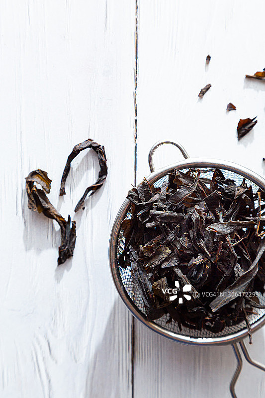 干盛开的萨利叶在一个滤茶器特写。替代草药。健康的生活方式的概念。有机的，自然的，发酵的柳草茶在一个轻木桌上。图片素材