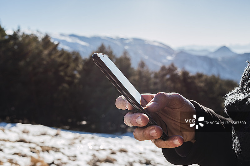 冬天，一名男子在雪地上使用手机图片素材
