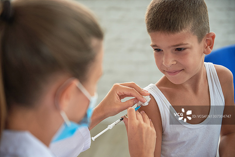 接种疫苗的概念。一位女医生给一个可爱的小男孩接种疫苗图片素材