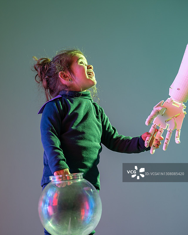 小女孩在未来场景中牵着机器人的手图片素材