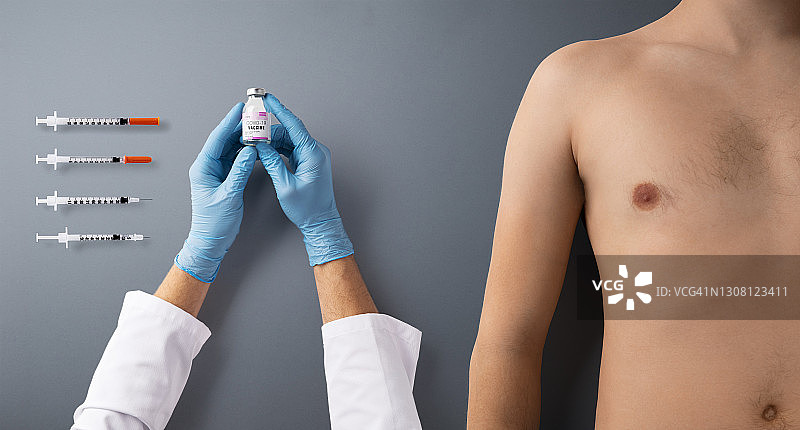手与注射器注射和上身裸露的男子躯干，covid-19和疫苗概念。图片素材