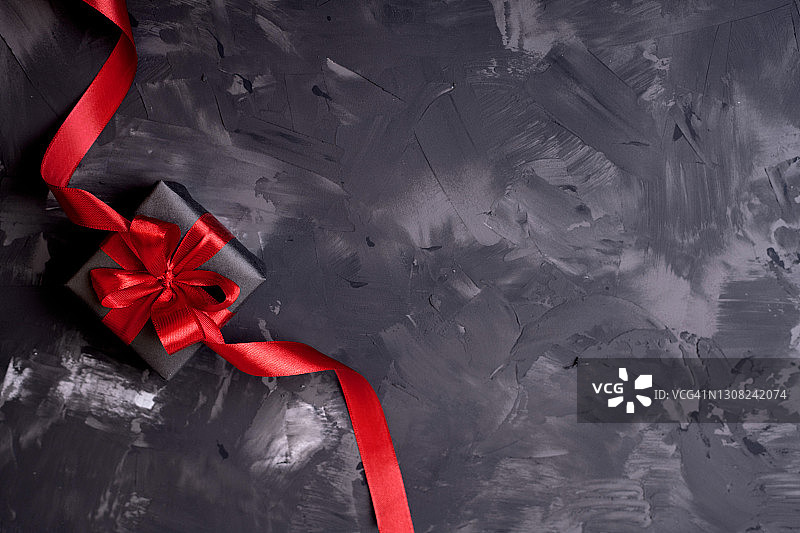 黑色礼盒与红色蝴蝶结黑色混凝土背景与复制空间图片素材