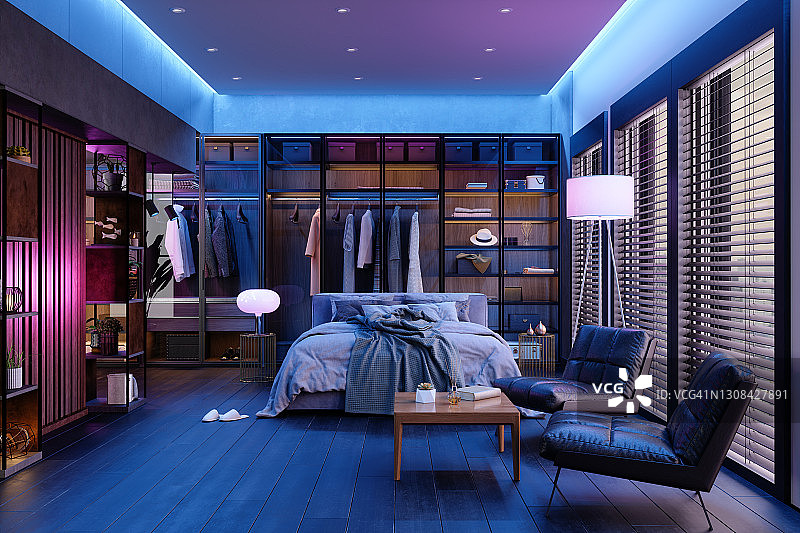 现代卧室室内在夜晚与霓虹灯。凌乱的床，衣柜里的衣服，扶手椅和落地灯。图片素材