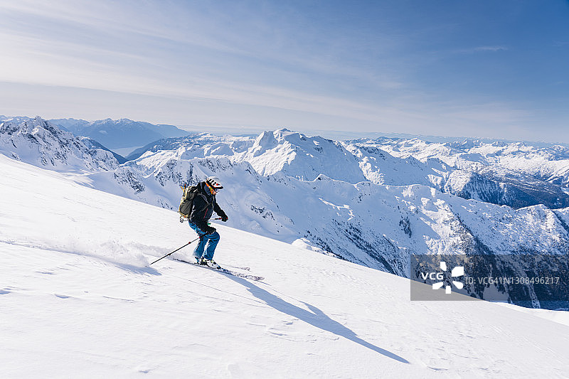 一名男性滑雪者从不列颠哥伦比亚省海岸山脉的冰川上滑下来图片素材