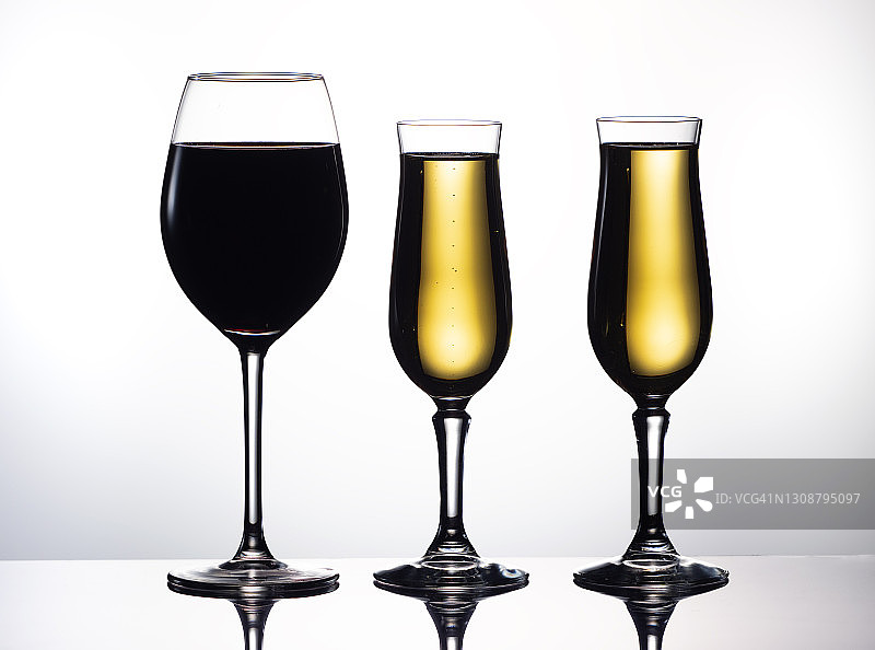 一杯红酒和一杯香槟，背景是白色。图片素材