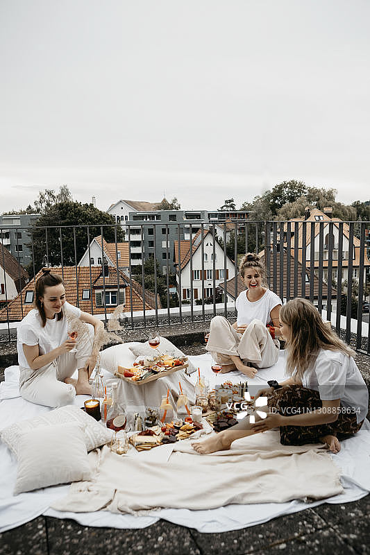 朋友们在屋顶露台上享受丰盛的野餐图片素材