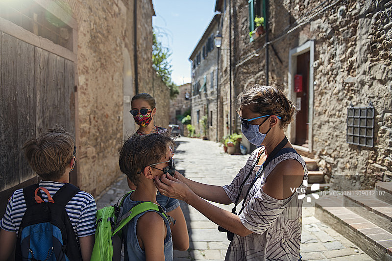 在新冠肺炎大流行期间，一家人游览美丽的意大利小镇图片素材