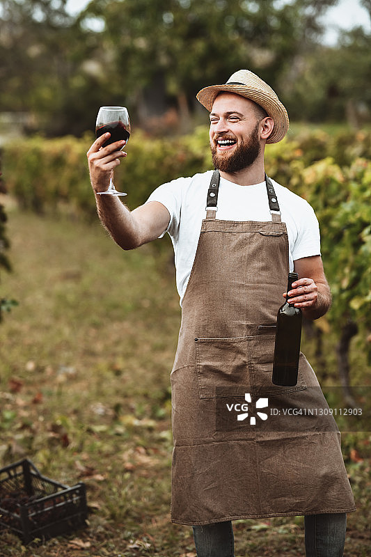 微笑的酿酒师展示他的红酒的质量图片素材
