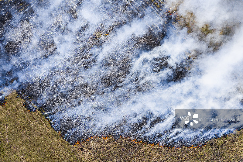 野地野火鸟瞰图。燃烧的草和巨大的烟雾图片素材