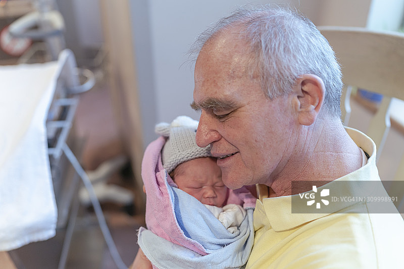 祖父第一次抱着孙子在病房里图片素材