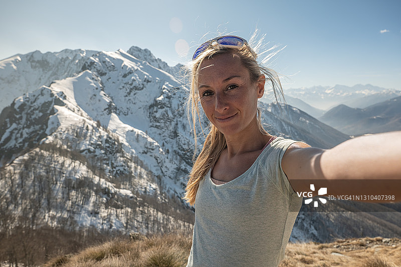 一名年轻女子在山顶自拍图片素材
