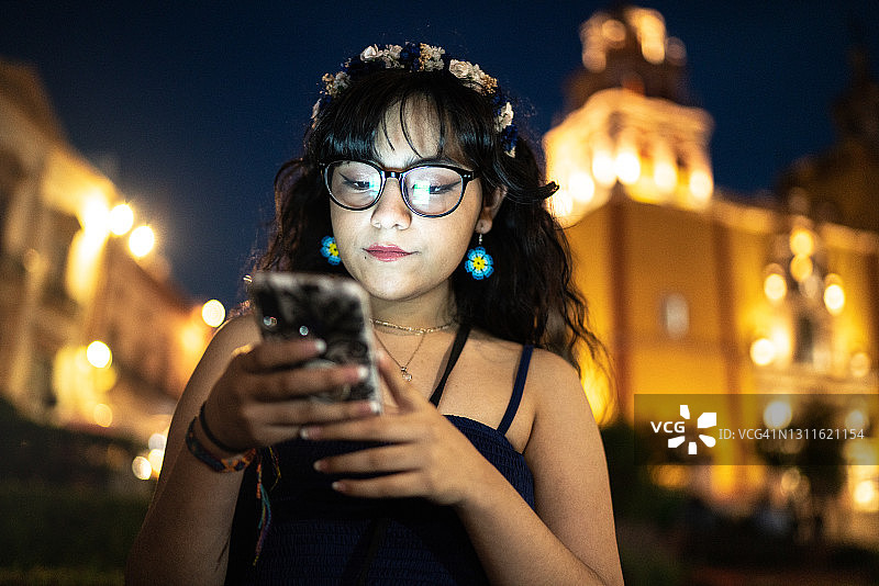 一名年轻女子在街上使用智能手机图片素材